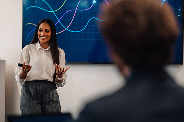 istock Businesswoman leading a presentation with charts on a screen 2225451663