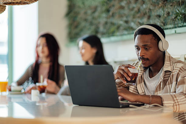 istock Focused freelancer working remotely in a cafe, enjoying a refreshing drink 2225456174