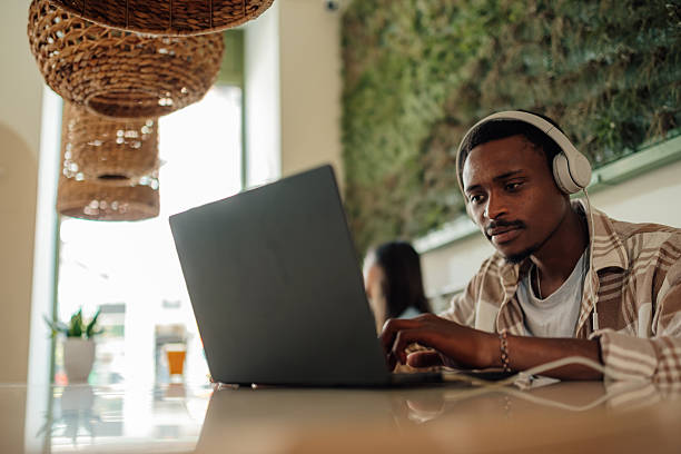 istock Focused young man working on laptop in modern cafe 2225456181