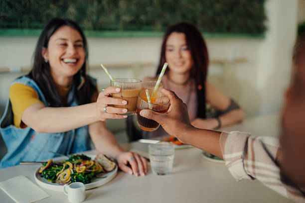 istock Young women toasting drinks at restaurant table 2225456257