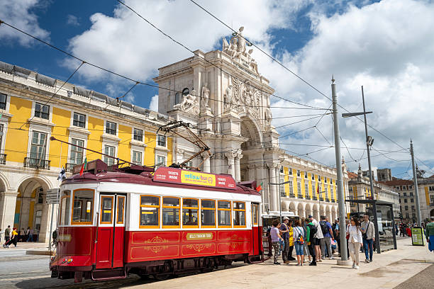 Lisbon, Portugal - May 4, 2025. Tourists waiting to board Vintage Tram by the Rua Augusta Arch at Commerce Square in Lisbon, Portugal