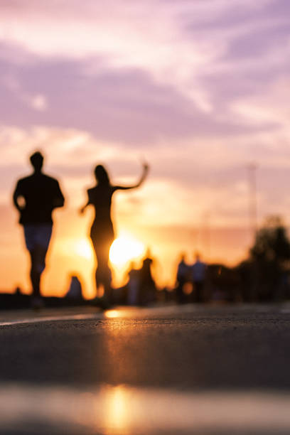 istock Unrecognizable young couple is walking in public park at sunset. 2225462559