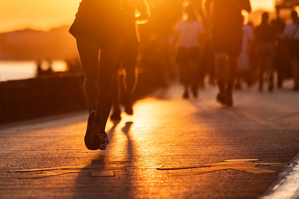 Young woman is jogging on pedestrian walkway at sunset.