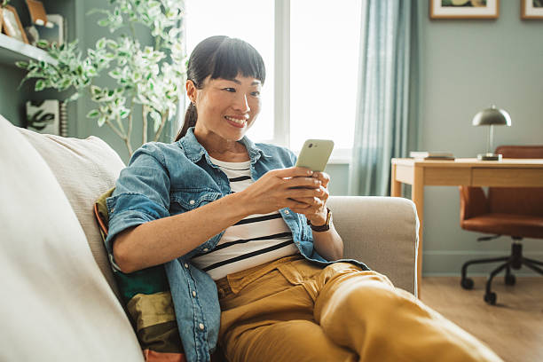 istock Young woman using a smart phone at home 2225465868