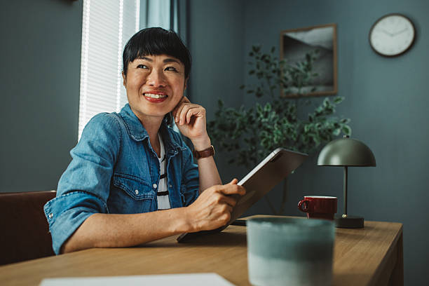 istock Smiling Asian female entrepreneur working on touchpad in the office 2225465972