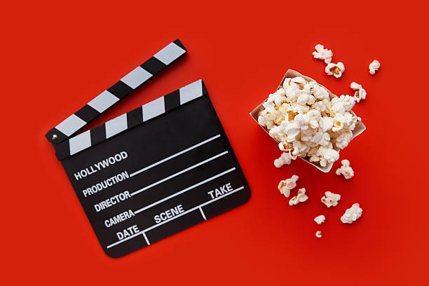 istock Striped box with popcorn and clapperboard on a red background 2225466283