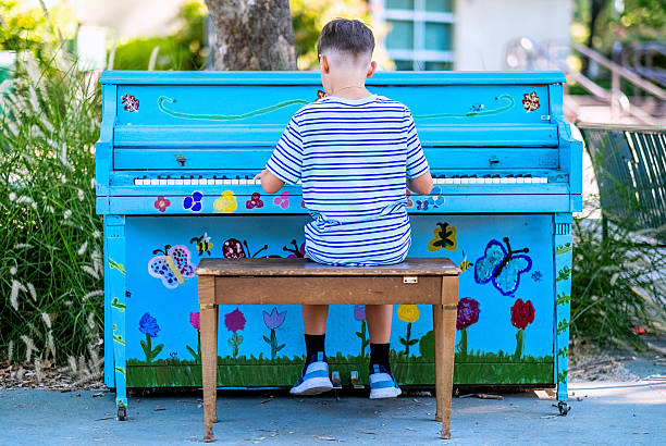 Little Boy Playing Piano at a Public park from behind