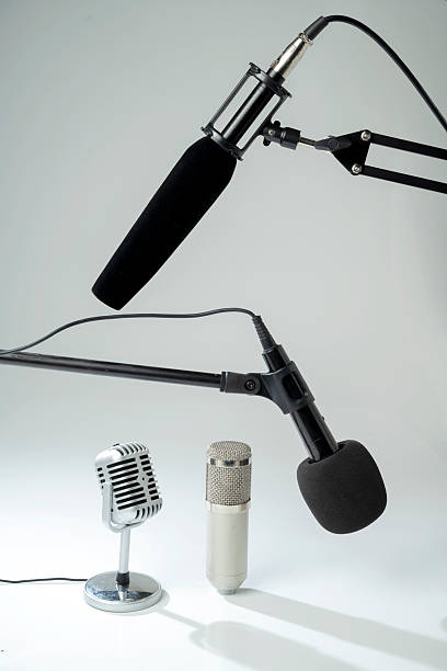 istock Studio and vintage silver microphone for podcasting or streaming on a boom arm with a white background 2225471369