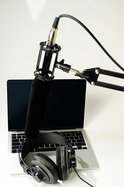 istock Studio microphone for podcasting or streaming on a boom arm with a laptop and headphones on a white background. Mockup or Copy space 2225471421