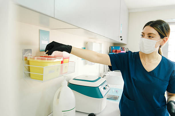 istock Dentist disposing medical waste into yellow safety container 2225473285