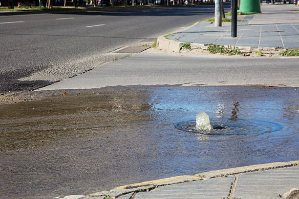 A clogged sewer in poor condition, with wastewater escaping due to upward pressure, leaving the entire street flooded.