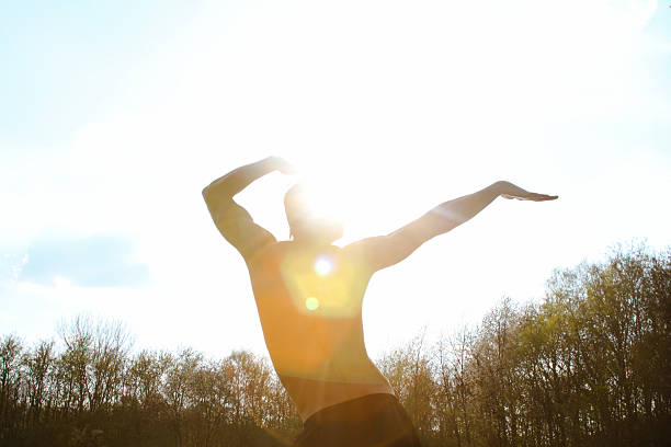 A fit Black athlete stretching his arms during a workout in a gym. Smiling male fitness trainer warming up, showing strength, health, and active lifestyle. Keywords: fitness, gym, stretching, athlete, workout, warm-up, trainer, active lifestyle, strong male model.