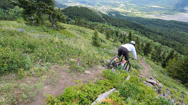 istock Young man mountain bikes over rock in trail 2225493758