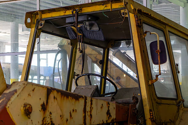 A mixed-race male construction professional sports a hard hat and high-visibility jacket while adeptly maneuvering a mini excavator in an outdoor setting, showcasing skillful earthmoving tasks.