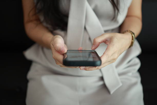istock Using phone, closeup of a hand holding smartphone on sofa 2225496882