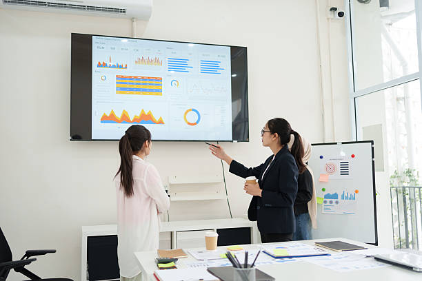 istock Group of business professionals analyzing data charts on screen during meeting in modern office. 2225498246