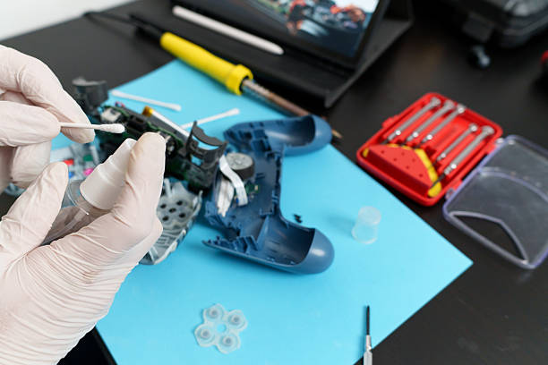 istock Technician repairing joystick with cleaning solution and cotton swab 2225502521