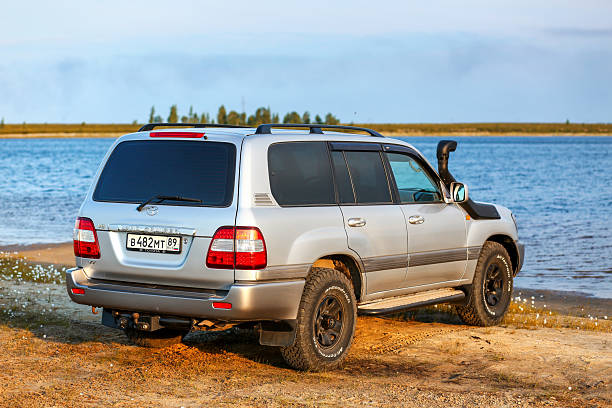 Yamal, Russia - July 28, 2024: Grey expedition vehicle Toyota Land Cruiser 100 near the lake in the northern tundra.