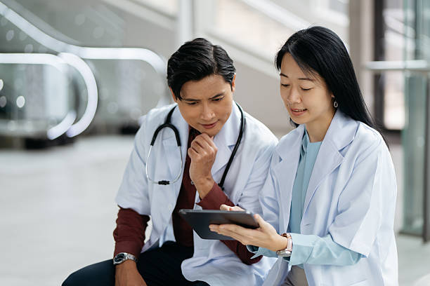istock Medical Team Reviewing Information on Digital Tablet 2225506038