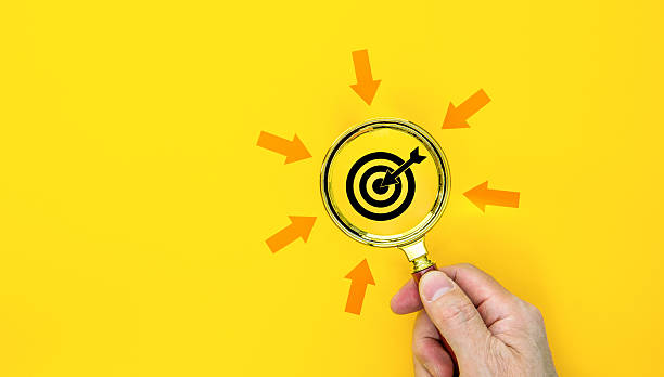 Business target concept with magnifying glass and target board on blue background