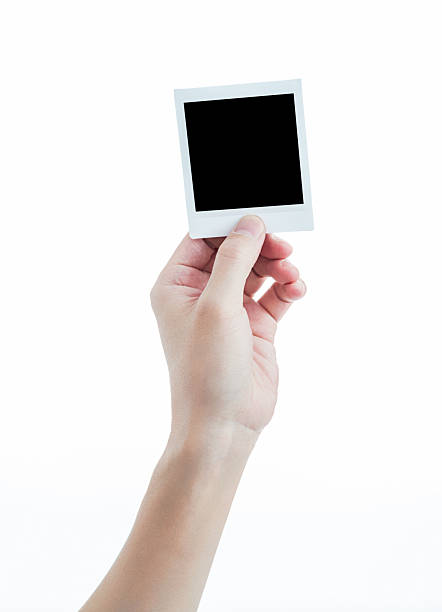 istock Human hand holding blank instant photo card on white background 2225510284