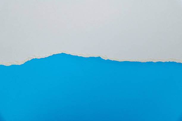 istock Tear white paper to reveal the blue background 2225510475