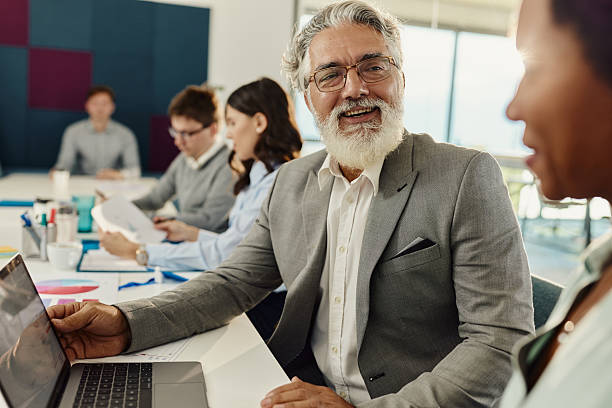 istock Happy business colleagues talking while working on laptop in the office. 2225515844