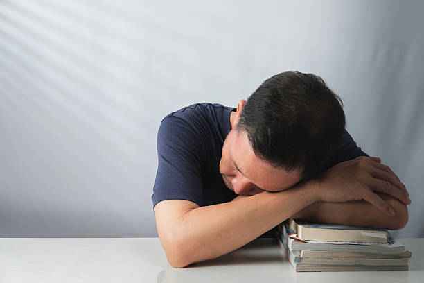 istock Asian Man Napping on Books 2225517001