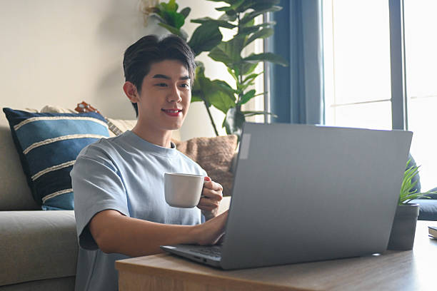 istock While working from home, a man smiles as he types a business report on his laptop. 2225517531