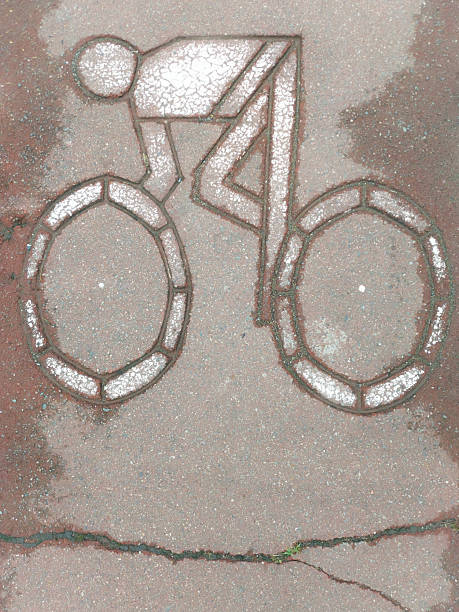 Bicycle lane sign painted on urban pavement showing a cyclist icon. Symbol of designated bike route, eco-friendly city transport, and safe infrastructure for cyclists.