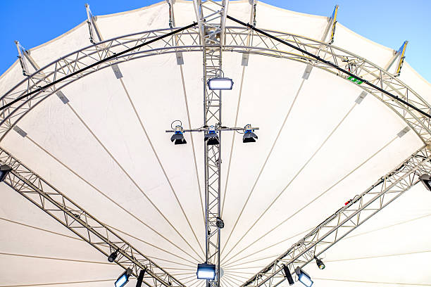 istock Central structure of a large outdoor canopy displaying metal framework and lights during an event setup in bright daylight 2225519579