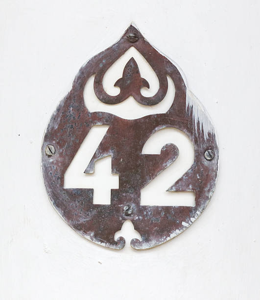 A rusted metal number 42 is on a white surface