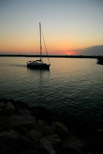 istock Yacht sailing into port at sunset. 2225522604