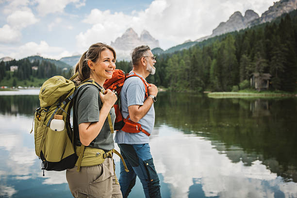 Mature couple standing and looking at lake in Dolomites