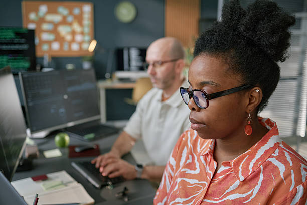 istock Young Black Woman Working on Computer Beside Middle Aged Caucasian Man 2225535065