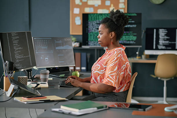 istock Young Adult Black Woman Developing Software Application at Office Workstation 2225535083