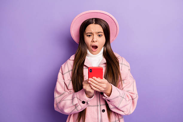 istock Portrait of attractive focused nervous girl using device browsing media negative dislike post isolated over bright violet purple color background 2225535266
