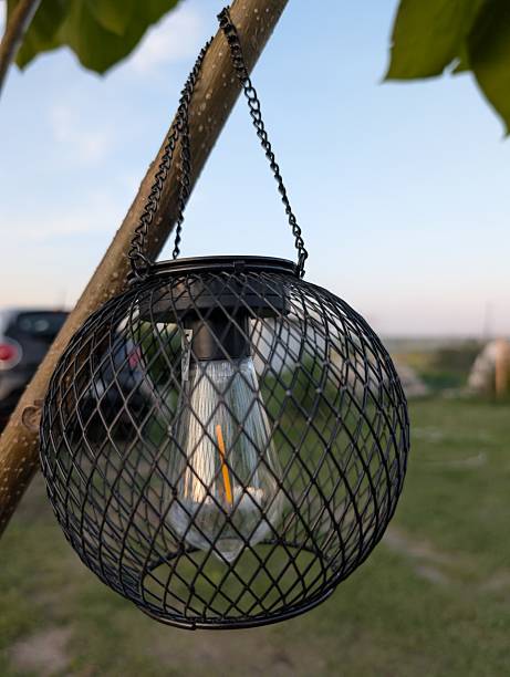 A beautifully designed hanging lantern creates a charming ambiance in a rustic outdoor setting