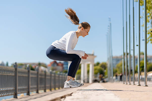 istock Young woman performing jump squats during outdoor workout 2225538256