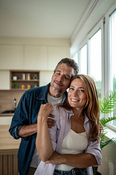 istock Happy mature couple embracing tenderly in their modern kitchen 2225539300