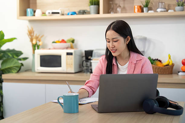 istock Working from Home: Woman studying with laptop and coffee 2225539906