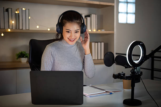 istock Podcast Host Engaging with Audience in Home Studio 2225540371