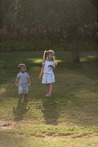 istock Two young children exploring nature in golden sunlight 2225540521