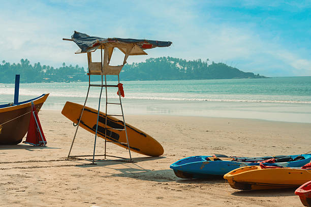 rental kayaks beside life guard tower at palolem beach in goa at sunny day