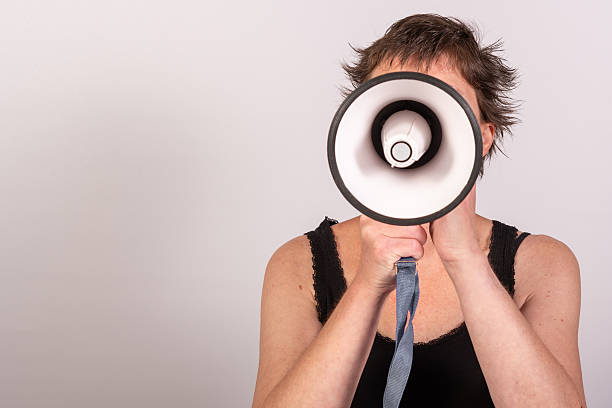 istock Anonymous woman with a megaphone pointing directly at the camera in the studio 2225544574