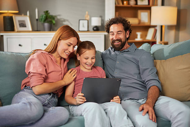 istock Happy family watching something funny on tablet at home 2225544910
