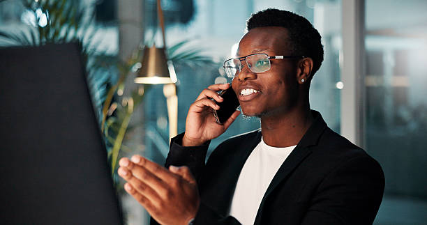 istock Project, black man and phone call with computer, smile and ideas for agency and online solution at night. Person, evening and consultant with technology, problem solving or planning with internet 2225547610