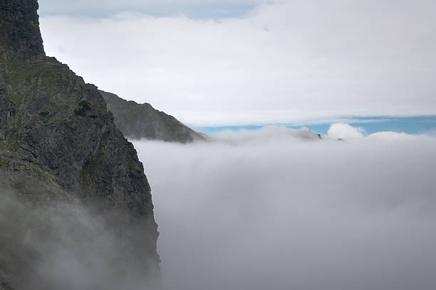 Clouds over the valley, a journey along a trail in the high mountains.