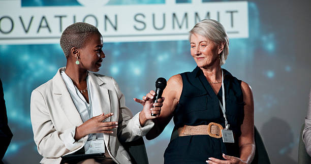 istock Women, speaker and seminar with mic for presentation, speech or business talk at workshop. Group, employees or spokesperson in meeting for tech campaign, AI development or global chat at auditorium 2225548362