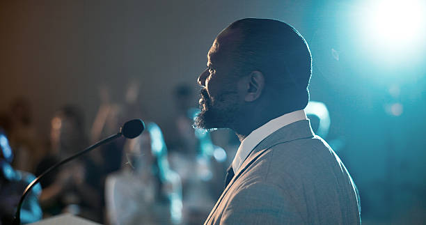 istock Businessman, speaker and speech for seminar, presentation or audience for conference or convention. Person, microphone and podium for international trade show, event speech or training workshop coach 2225548463